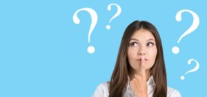 woman looking quizzical surrounded by question marks