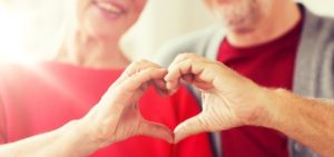 senior couple making a heart shape with their hands