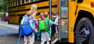 group of kids getting on a school bus