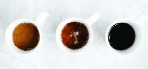 three cups of coffee with varied amounts of milk, light, medium and dark