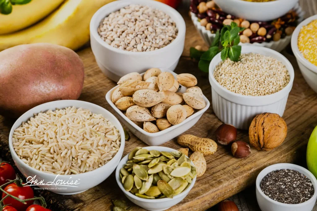 Assorted healthy, complex carbohydrates sitting on a rustic wooden tabletop